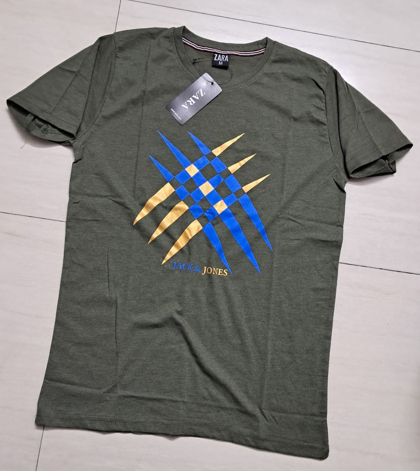 a green shirt with blue and yellow design on it